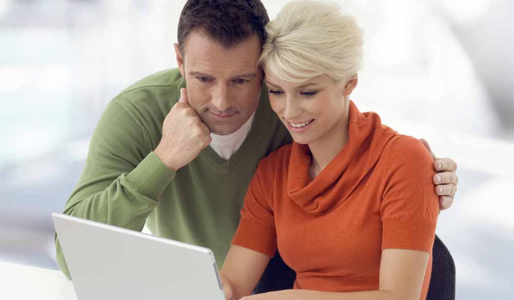 couple viewing a web design on a laptop